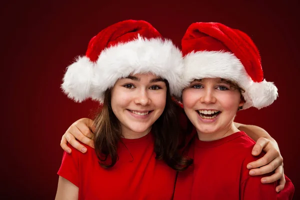 Crianças Santa Chapéus Posando Fundo Vermelho — Fotografia de Stock