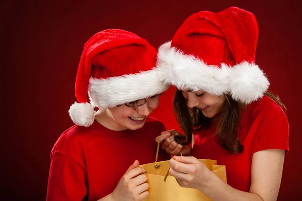 Barn Santa Hattar Poserar Röd Bakgrund — Stockfoto