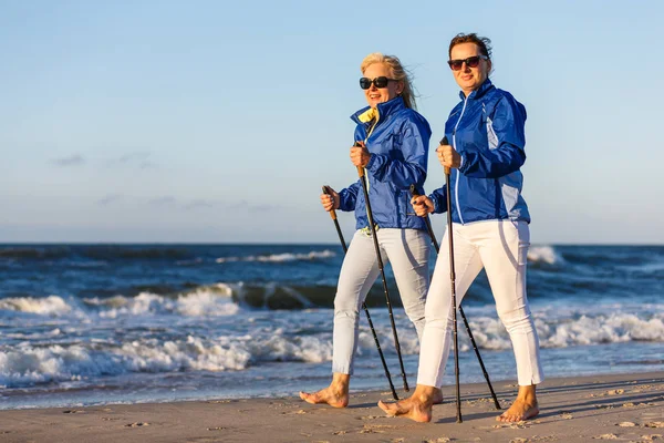 Duas Mulheres Meia Idade Andando Com Paus Turísticos Beira Mar — Fotografia de Stock