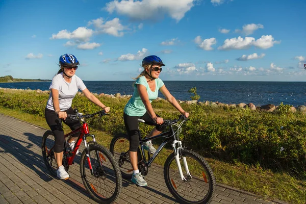 Två Aktiva Kvinnor Sportkläder Ridning Cyklar Stranden — Stockfoto