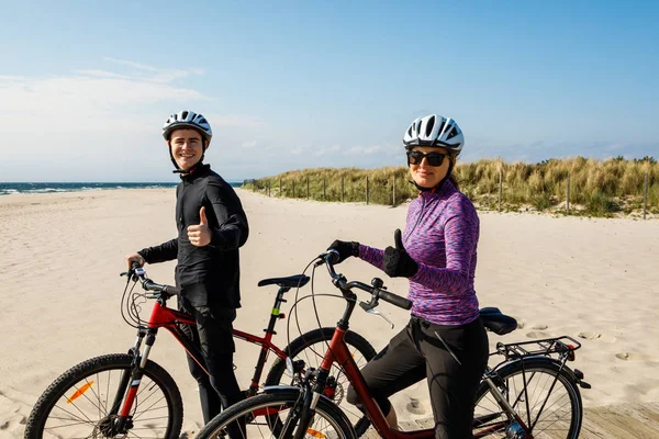 穿着运动服在海滨骑自行车的年轻夫妇 — 图库照片