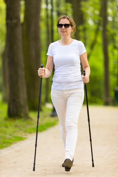 Mujer Ropa Blanca Casual Caminando Parque Primavera Usando Palos Turísticos — Foto de Stock