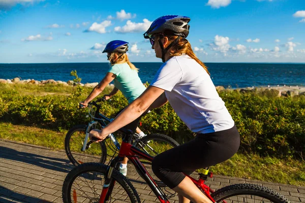 Två Aktiva Kvinnor Sportkläder Ridning Cyklar Stranden Sommaren — Stockfoto