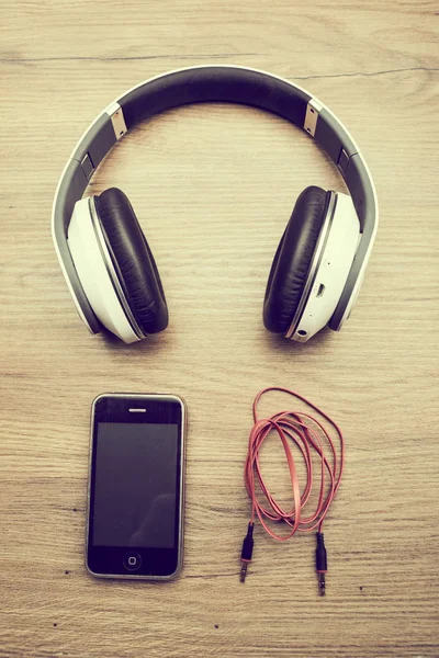 Kopfhörer und Smartphone auf dem Tisch — Stockfoto