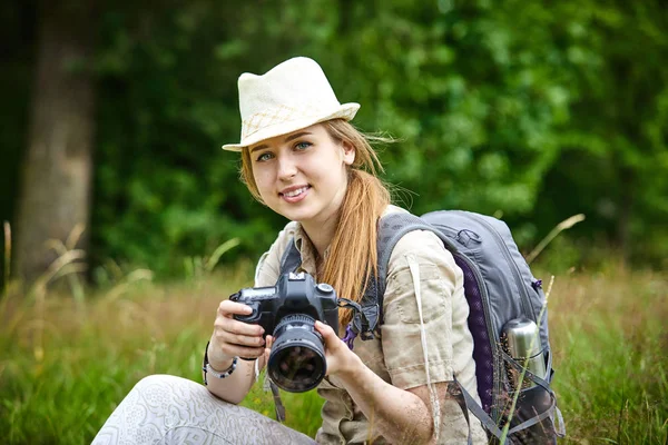 Femme avec caméra sur prairie verte — Photo