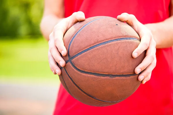 Mãos segurando bola de basquete — Fotografia de Stock
