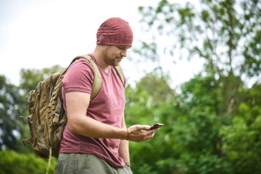 güneşli bir gün, çayır smartphone ile genç adam 