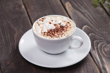 fincan sıcak cappuccino ve hatmi ahşap tablo