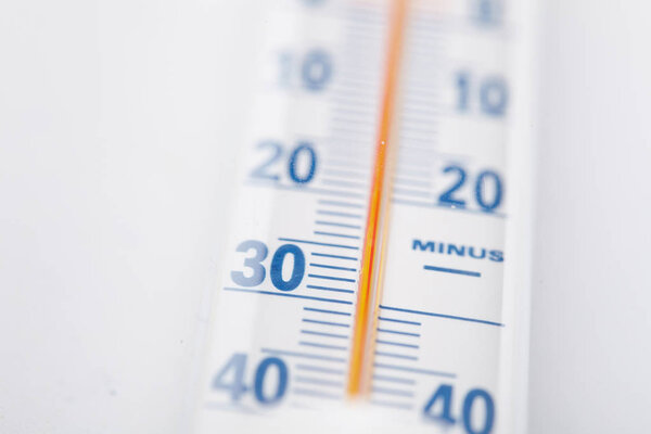 Термометр с шкалой Цельсия на белом фоне крупным планом
