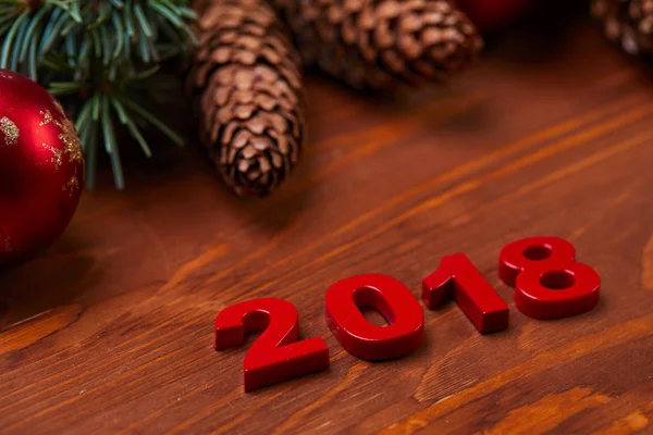 松ぼっくりと木製のテーブルの装飾的な数字 2018 とクリスマス リース — ストック写真