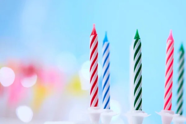 Colorful birthday candles on blue background