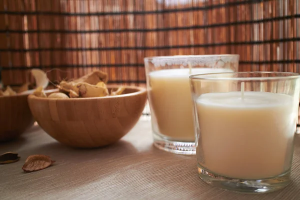 spa dry plants in wooden bowl with candles in glasses, spa concept