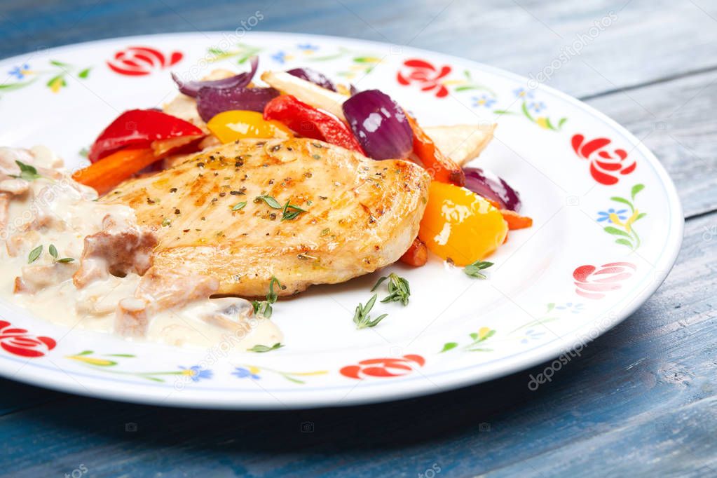 chicken with vegetables on white plate, close-up   