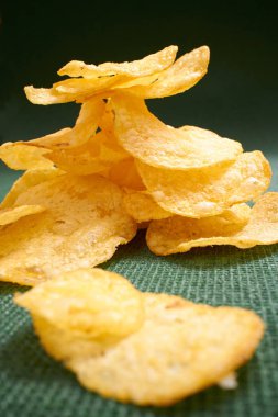Yeşil masa örtüsü üzerinde gevrek patates cipsi 