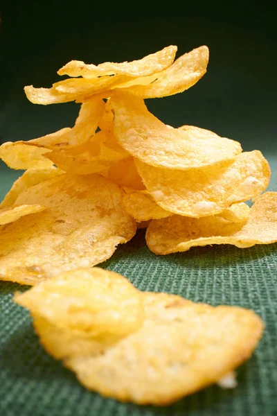 Yeşil masa örtüsü üzerinde gevrek patates cipsi 