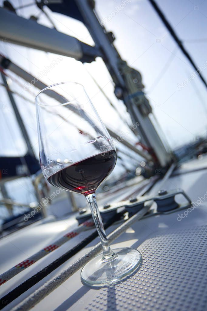 glass of red wine on deck of yacht