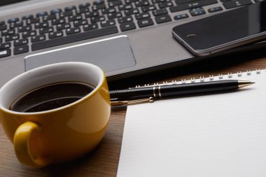 defter ile kahve fincanı ve işyeri, iş kavramı smartphone ile dizüstü bilgisayar