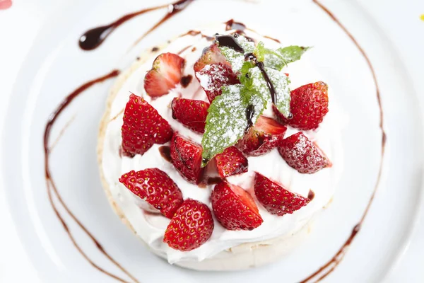 Strawberry pavlova cake on white plate, close-up