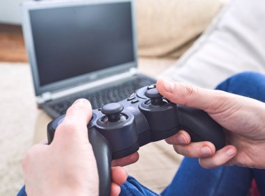 man holding joystick controllers while playing video games at home clipart