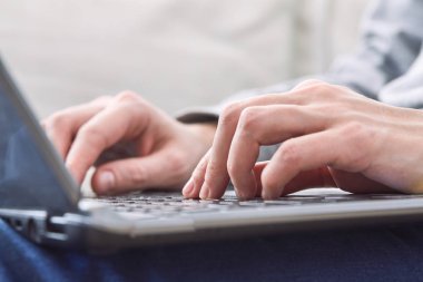 adam kanepede oturan ve dizüstü bilgisayar, kullanarak yakın çekim 