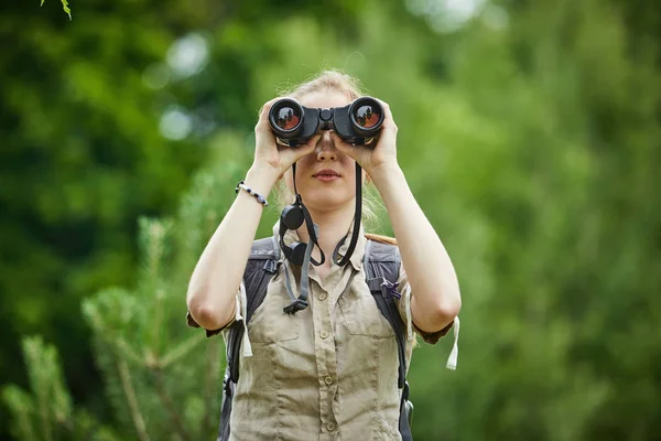 Woman with backpack looking at binoculars — Stock Photo, Image