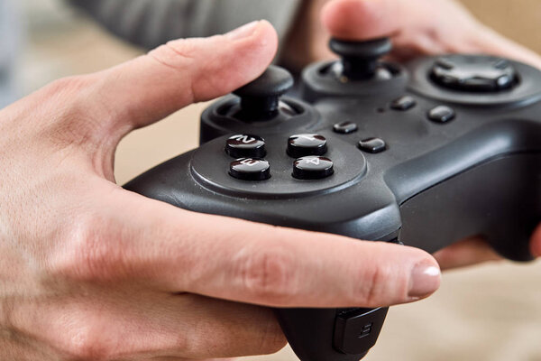 man holding joystick controllers while playing video games at home