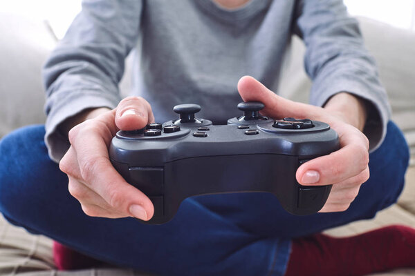 man holding joystick controllers while playing video games at home