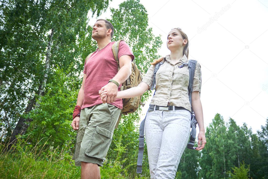 two travelers walking in forest at sunny day 