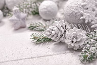 Masa arkasında süslemeleri olan karlı Noel ağacı dalları