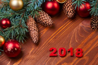 Ahşap arka planda kırmızı ve altın topları olan Noel çelengi, yakın görüş