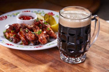 Ahşap kesme tahtasında meze ile servis edilen filtresiz bira pint, yakın çekim 