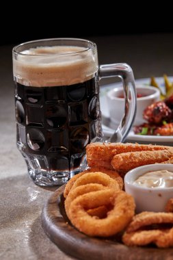 Ahşap kesme tahtasında meze ile servis edilen filtresiz bira pint, yakın çekim 
