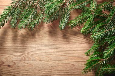 Tahta arka planda ağaç dalları olan Noel kartı