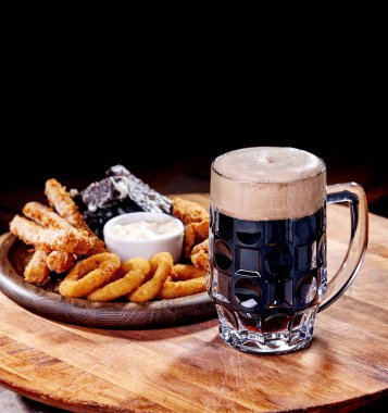 Ahşap kesme tahtasında meze ile servis edilen filtresiz bira pint, yakın çekim 