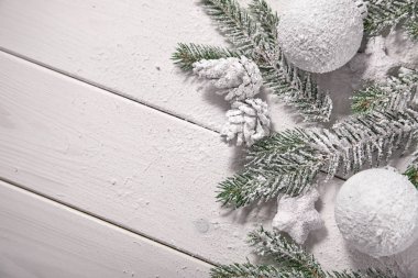 Karlı ağaç dalları ve ahşap arka planda süslemeleri olan Noel kartı