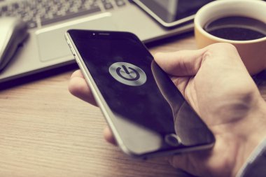 Erkek el ele tutuşan modern akıllı telefon ekranda güç düğmesi, iş konsepti 