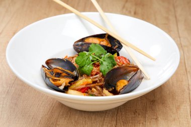 Beyaz tabakta karabuğday erişteli midyeler, yakın görüş. 