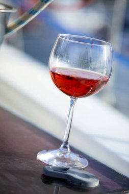 Yat yüzeyinde parlak güneş ışığında bir bardak şarap.