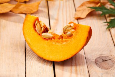 Taze balkabağı ve yapraklar ahşap arka planda