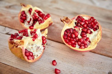 ripe organic pomegranate on wooden background, close-up 
