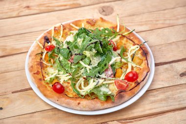 Tahta arka planda taze sebzeli pizza.