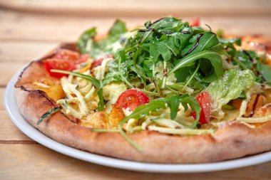 Tahta arka planda taze sebzeli pizza.