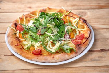 Tahta arka planda taze sebzeli pizza.