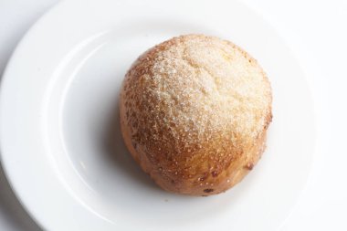 Beyaz tabakta taze çörek, yakın plan. 