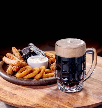Ahşap kesme tahtasında meze ile servis edilen filtresiz bira pint, yakın çekim 