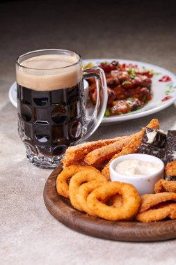 Ahşap kesme tahtasında meze ile servis edilen filtresiz bira pint, yakın çekim 