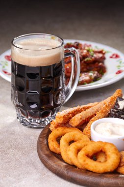 Ahşap kesme tahtasında meze ile servis edilen filtresiz bira pint, yakın çekim 