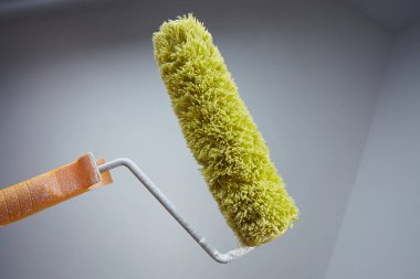 Boya yuvarlanan boya gri duvar arka planında 