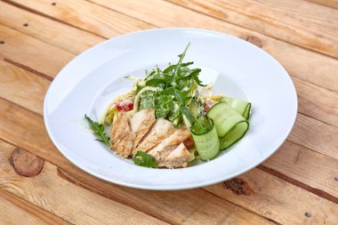 Beyaz tabakta taze sebzeli ızgara tavuk, yakın görüş.