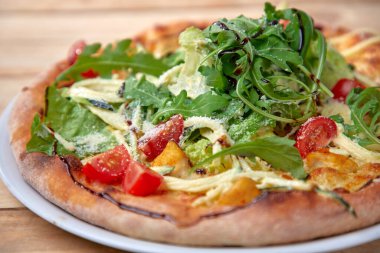 Tahta arka planda taze sebzeli pizza, yakın görüş.